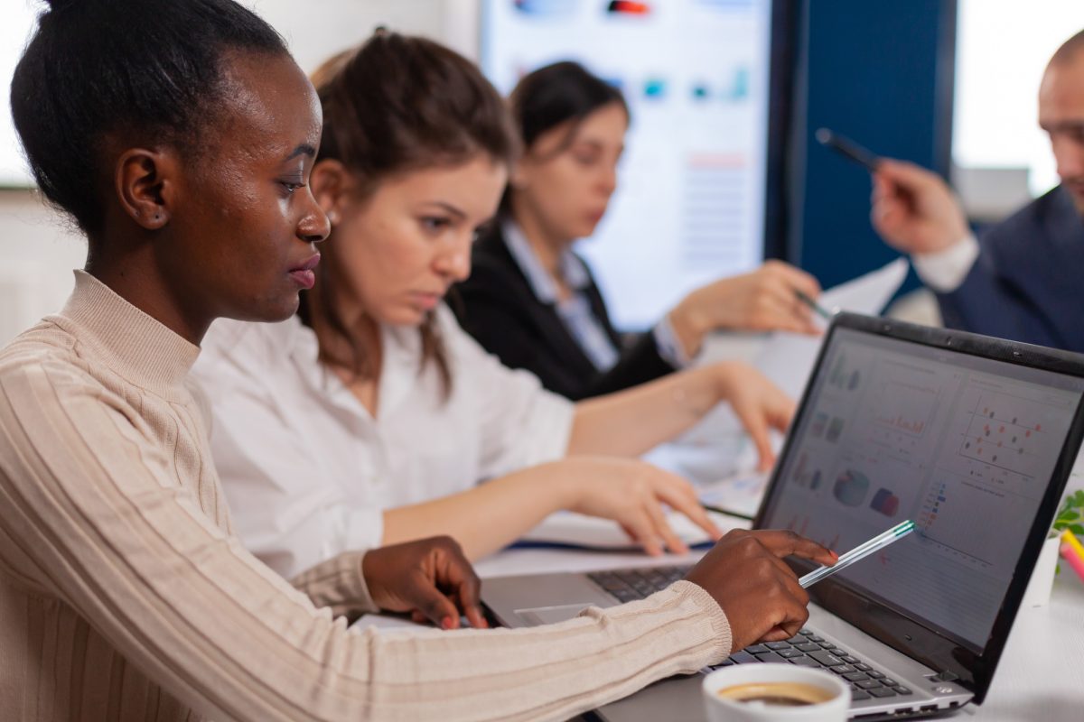 Cheerful african business lady typing on laptop