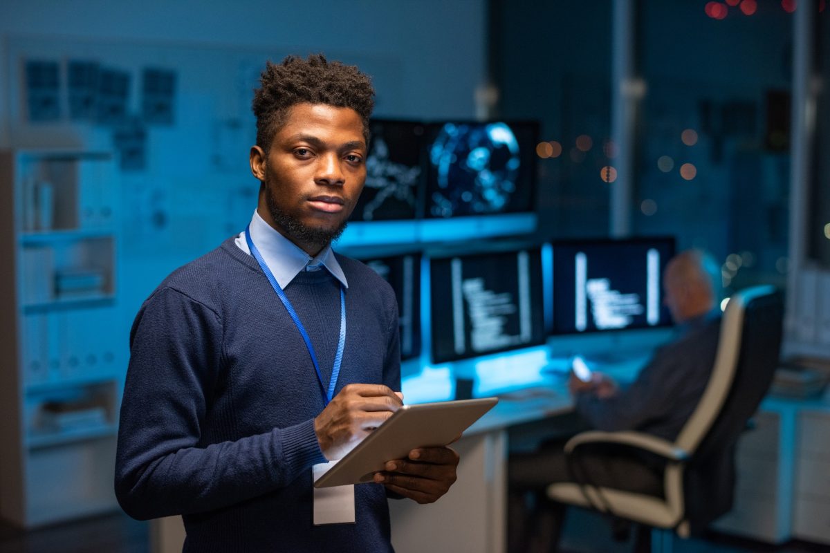 Young serious African programmer with tablet